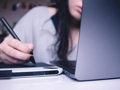 A person using a stylus and on their computer